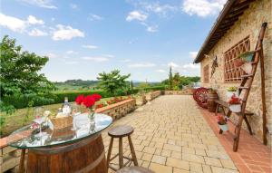 a patio with a glass table and some flowers at Poggio Agli Ulivi in Megognano