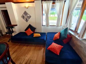 un soggiorno con 2 divani blu con cuscini colorati di Drey at Druv Dakshin Farm Resort a Padinjarathara