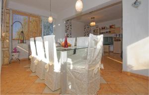 a dining room with a glass table and white chairs at Holiday Home Zdrelac 06 in Ždrelac