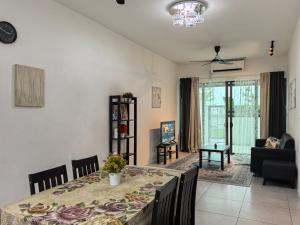 una sala da pranzo con tavolo e un soggiorno di Royal Comfort Suite Meritus near swimming pool a Perai