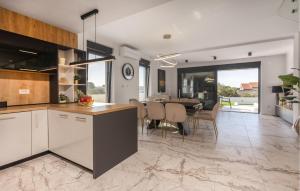 a kitchen and dining room with a dining table at Gorgeous Home In Banjol in Banjol +32 photos