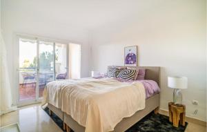 a white bedroom with a large bed and a balcony at 2 Bedroom Lovely Apartment In Marbella in Marbella
