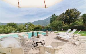Un patio con sillas blancas y una piscina. en Amazing Home In Camaiore Lu With Wifi, en Camaiore