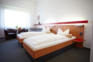 a hotel room with two beds and a table at Schönblick - Christliches Gästezentrum in Schwäbisch Gmünd +17 photos