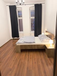 レグニツァにあるApartament Plac Klasztornyのベッドと木の床のある寝室