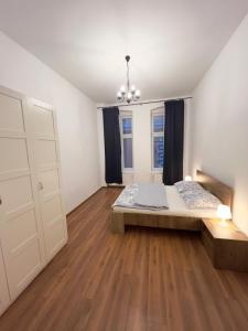 レグニツァにあるApartament Plac Klasztornyのベッドルーム1室(ベッド1台、ドレッサー付) +3枚の写真