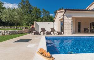 una piscina con sillas y una casa en Stunning Apartment In Labin With Sauna, en Labin 34 fotos más