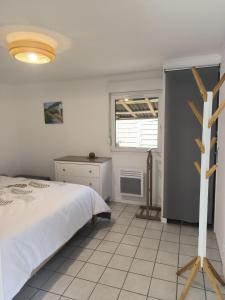 a bedroom with a white bed and a window at Gîte de la Mardelle in Viarmes