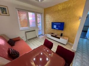 a living room with a red couch and a tv at Rakovica Centar in Belgrade