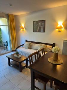 a living room with a bed and a table at Chez Adelaïde in Levernois