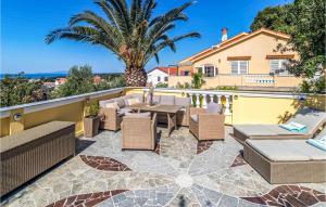 a patio with a table and chairs on a balcony at Beautiful Home In Banjol With Sauna in Banjol +48 photos