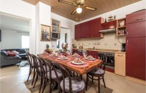 a kitchen with a wooden table with chairs and a dining room at Beautiful Home In Banjol With Sauna in Banjol