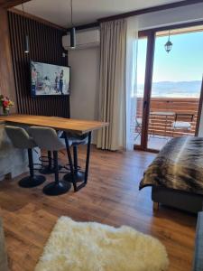 een eetkamer met een tafel en een balkon bij Studio Todorka in Bansko