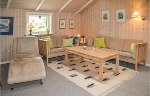 a living room with a couch and a table at Holiday Home Solbærvangen Oksbøl X in Ovtrup +15 photos