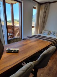 een vergaderruimte met een houten tafel en een bed bij Studio Todorka in Bansko