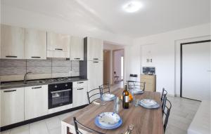 a kitchen with a wooden table and chairs in a room at Stunning Apartment In Nicotera Marina in Nicotera Marina