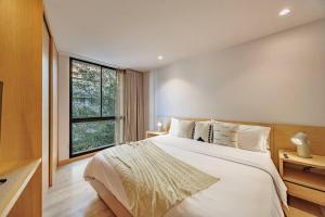 メデジンにあるExquisito Estudio en Provenzaの大きな白いベッドと窓のある寝室