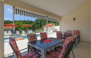 una sala da pranzo con tavolo, sedie e piscina di Amazing Home In Vodnjan With Wifi a Vodnjan (Dignano)