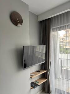 a living room with a tv and a clock on the wall at The Yacht apartments-tranquiliti and comfort in the heard of Alanya 200m to Keykubat beach in Alanya +26 photos