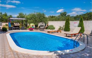 basen w ogrodzie z ławką i stołem w obiekcie Three-Bedroom Holiday Home In Murvica w mieście Murvica