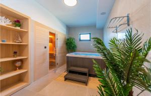 Un baño con bañera y una planta en maceta. en Awesome Home In Biograd Na Moru, en Biograd na Moru