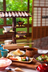 einen Tisch mit Teller mit Speisen und Schalen in der Unterkunft Hatago Kayausagi in Hita