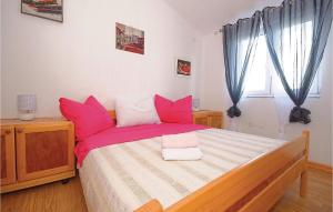 a bedroom with a large bed with pink pillows at Holiday Home Zdrelac 06 in Ždrelac