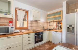 une cuisine avec des armoires blanches et une fenêtre dans l'établissement Amazing Home In Malinska With Kitchen, à Malinska