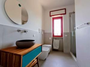 a bathroom with a sink and a toilet and a mirror at Villa Vento del Sud in Villa Castelli +18 photos