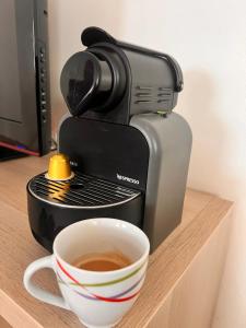a coffee maker and a cup of coffee on a counter at Family apartment NZ in Tangier