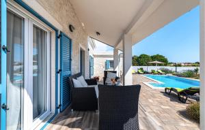 eine Terrasse mit Stühlen und einem Pool in der Unterkunft Stunning Home In Privlaka With Wifi in Privlaka