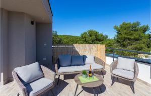 a patio with two chairs and a table on a balcony at Four-Bedroom Holiday Home In Premantura in Premantura