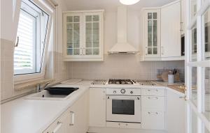 a white kitchen with a sink and a stove at Holiday Home Pomer Ii in Pula