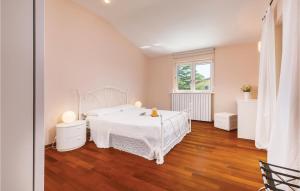 a white bedroom with a white bed and a window at Holiday Home Pomer Ii in Pula