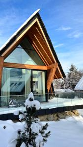 a house covered in snow with a roof at Górski Domek Zakopane in Kościelisko