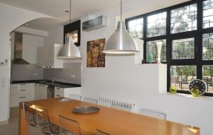 a kitchen with a wooden table and some windows at Lovely Home In Santa Susanna With Wifi in Santa Susanna
