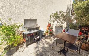kuchnia na świeżym powietrzu ze sprzętem do grillowania i stołem w obiekcie Amazing Apartment In Narbonne With Wifi w mieście Narbona