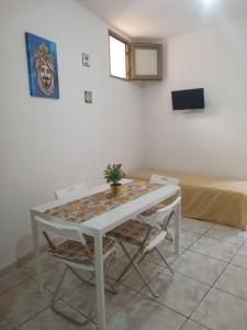 Una mesa y sillas blancas en una habitación. en Appartamento del Moro, en Agrigento