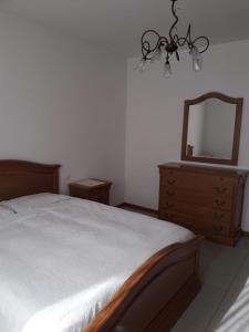 - une chambre avec un lit, un miroir et une commode dans l'établissement La casa dei nonni, à Villafranca di Verona 15 autres photos