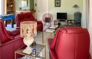 a living room with red couches and a table at Beautiful Home In Prades-Sur-Vernazobre in Prades-sur-Vernazobre