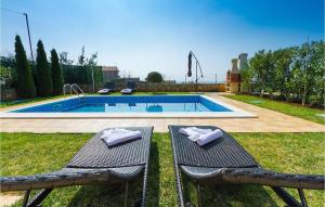 a swimming pool with two chairs in the grass at Villa Vera in Poreč