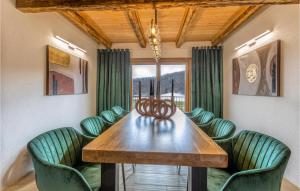 una sala da pranzo con tavolo in legno e sedie verdi di Awesome Home In Barlete With Kitchen a Barlete