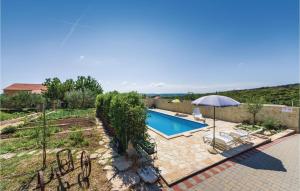 a swimming pool with an umbrella and chairs at Awesome Apartment In Vrana With Wifi in Vrana +19 photos