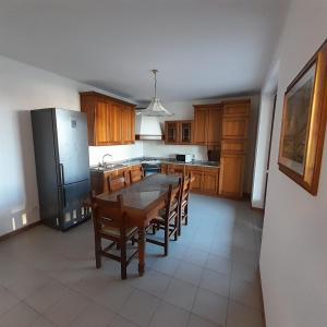 une cuisine avec une table, des chaises et un réfrigérateur dans l'établissement La casa dei nonni, à Villafranca di Verona
