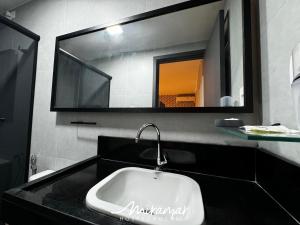 a bathroom with a sink and a mirror at Flat No Bessa com Varanda Gourmet in João Pessoa +15 photos