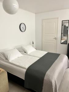 a bedroom with a large bed with a clock on the wall at Kodikasta majoittumista hyvällä sijainnilla! in Kankaanpää