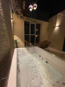 a white bath tub in a bathroom with a window at شقق لافندر للشقق المخدومة الأقتصادية in Taif +73 photos