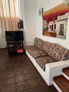 a living room with a couch and a television at El encuentro in Unquillo