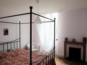 ポン・アン・ロワイヤンにあるChez Marieのベッドルーム(天蓋付きベッド、暖炉付)