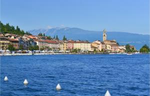 a large body of water with small white sailboats at Cozy Apartment In Salò With Lake View in Salò +23 photos